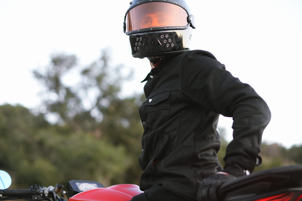 man sitting on motorbike wearing a helmet and jacket with motorcycle armor
