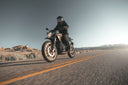 low angle picture of a man riding a motorcycle in the sun