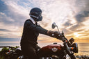 man sitting on a chopper in front of the sunset